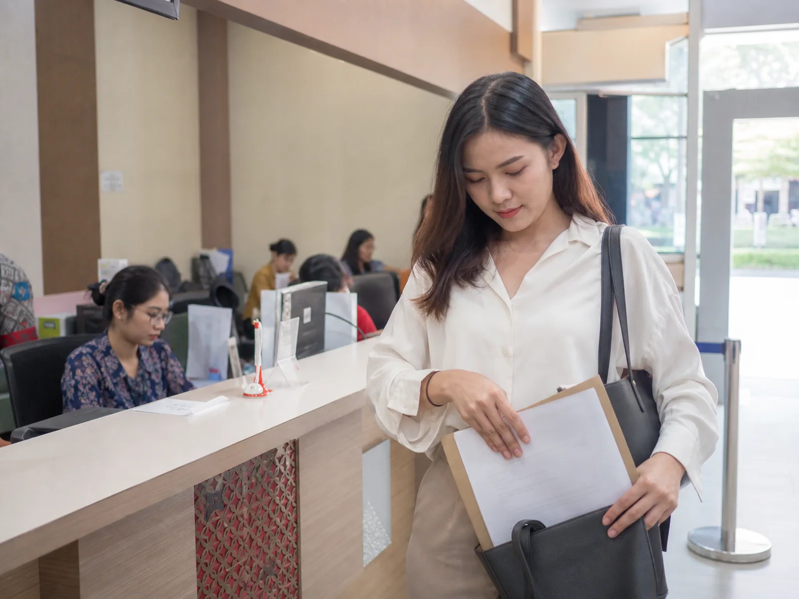 Resident checking a completed document packet before leaving the counter.