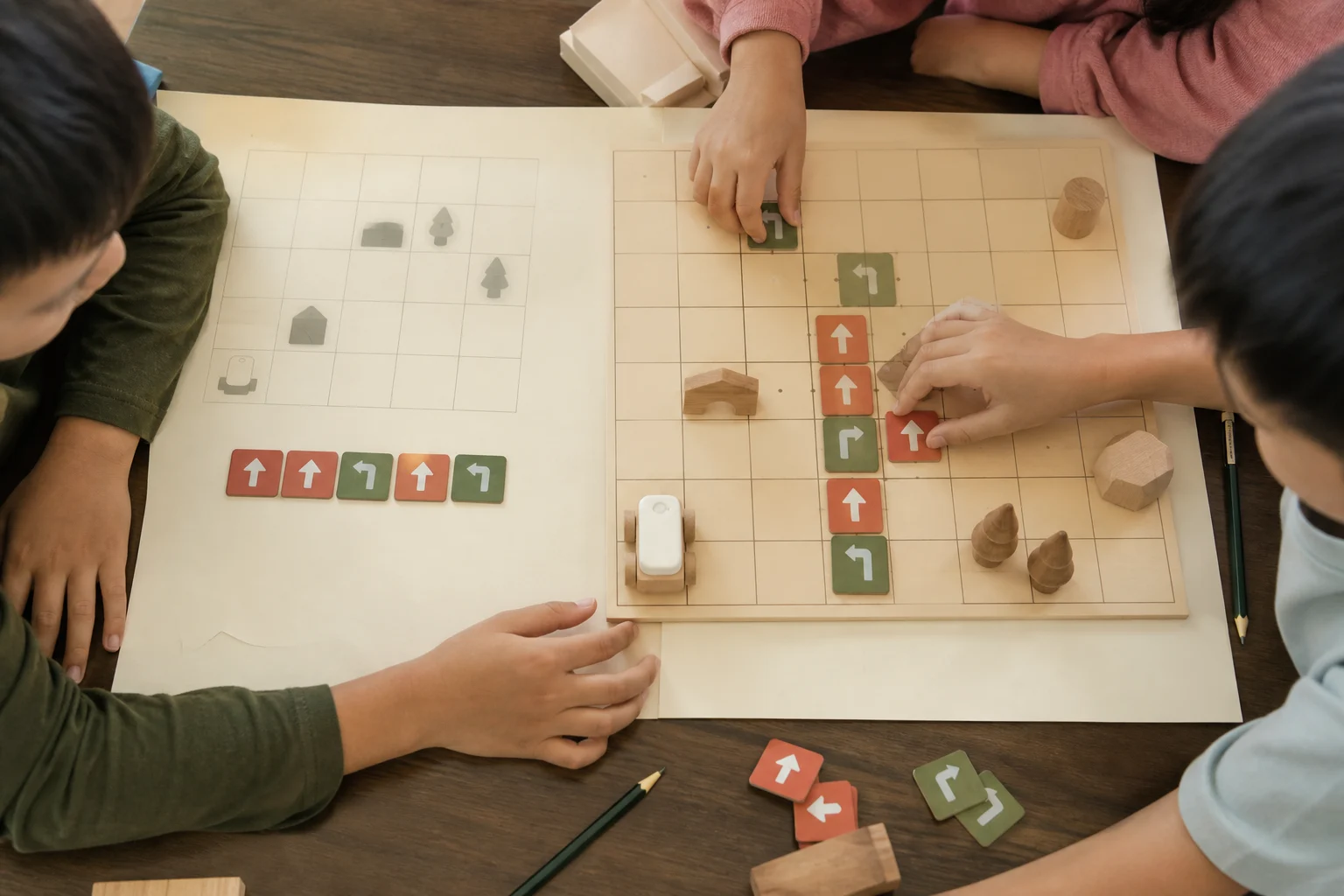 Three children work together to arrange a rover route at a weekend class table.